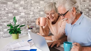 senior couple laptop smiling gettyimages