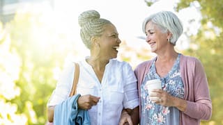 two older people walking outside smiling