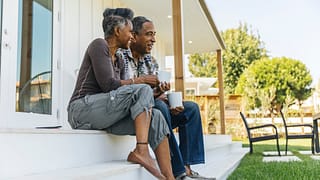 two people sitting on a porch outside