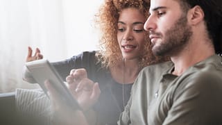 Couple looking at something together on a tab.width PsznaUo