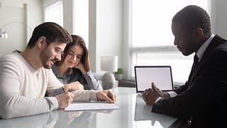 Couple signing paperwork with an agent ooiUfy.width