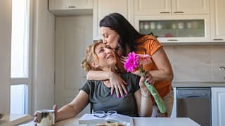 Daughter gives flowers and a hug to mother vm.width .jpg