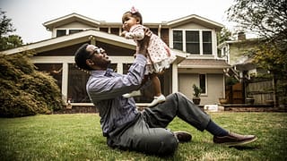 Father and toddler daughter play in homes bac.width leyKMuB