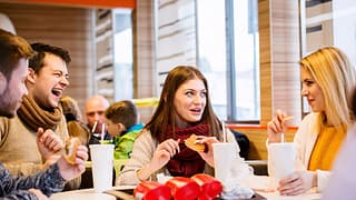 Group of friends eating fast food burgers and.width .jpg
