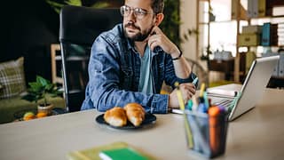 Man using laptop looks away appearing to be i.width mpyFQA