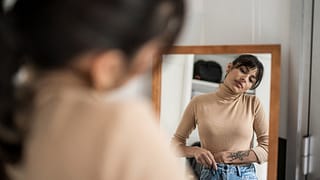 Person trying on clothing in mirror. EambWvL.width
