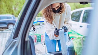 Woman loading car with groceries looks over h.width QbypC