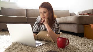Woman using her laptop on her living room flo.width CvTcp