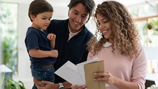 Young family smiles while looking through mai.width YCkchbc