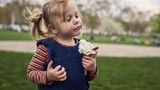 Young girl eating ice cream cone YBZc.width
