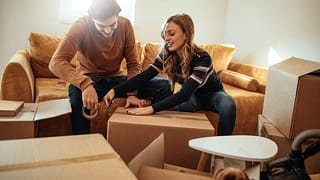 couple packing moving boxes.width