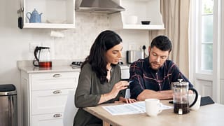 couple talking over papers in kitchen KRXubp.width