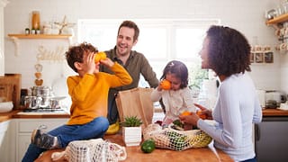 family unpacking groceries in kitchen.width