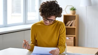 person with pen and paperwork RhgBV.width