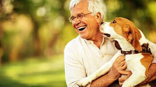 senior man smiling being licked by dog gettyimages .jpg