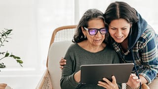 two people looking at a tablet and smiling