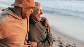 two people smiling hugging on the beach