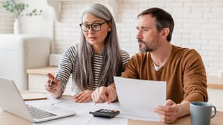 two people with bills and laptop hENMu.width .jpg