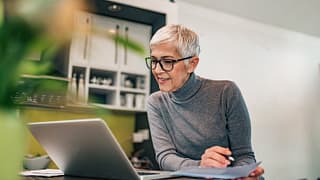 woman at home with laptop and paperwork iLty.width