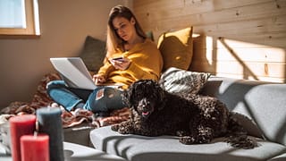 woman holding credit card with dog and laptop.width ECGu.jpg