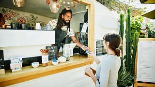 woman paying food truck owner with credit car.width aTVnc.jpg