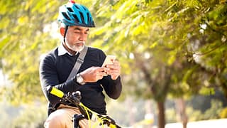 Man looking at his cell phone while riding hi.width TIdVD.jpg