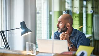 Mature man at desk looking off in thought ZmW.width .jpg