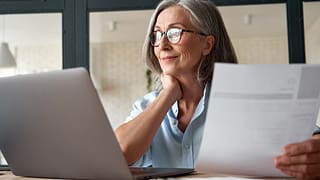 Mature woman working from laptop with documen.width ZiqNtKV.jpg