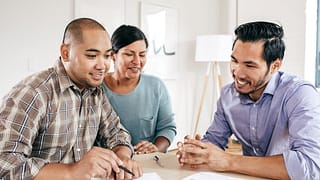 Mortgage lender goes over documents with coup.width Omt.jpg