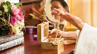 Woman choosing necklace from jewelry box NAu.width .jpg