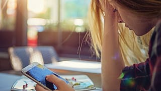 Woman holding smashed cell phone WAun.width .jpg