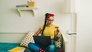 Woman relaxing at home looking at a credit ca.width cRZ.jpg