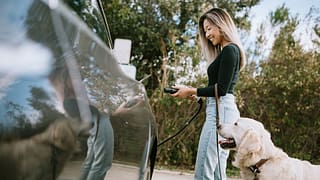 Woman with dog about to charge her electric c.width gkkvUm.jpg
