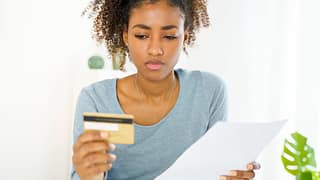 Young woman looking at credit card uQDfnW.width .jpg