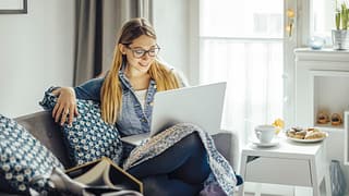 Young woman using laptop on the couch. KUYgdG.width .jpg
