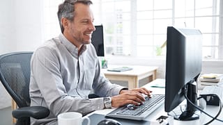 a smiling person at a computer gettyimages .jpg