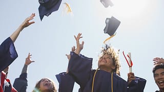 college graduates throwing mortarboards into .width mAUVTM.jpg