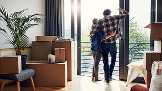 couple at window with moving boxes in new hom.width VeumdPo.jpg