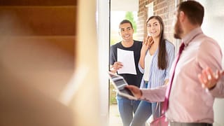 couple with realtor entering house cYeeLe.width .jpg