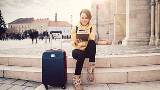 female traveler with suitcase tablet and cred.width sQbWMG.jpg