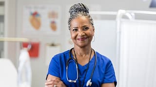 getty nurse smiling at camera with arms crossed healthcare.jpg