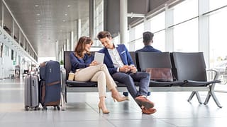 man and woman sitting at airport opGWJ.width .jpg