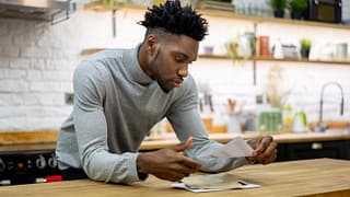 man in kitchen opening mail ecOhBNj.width .jpg