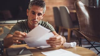 man with bills at desk fggd.width .jpg