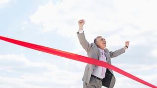mature man businessman crossing finish line.jpg