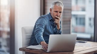 older man denim shirt laptop gettyimages .jpg