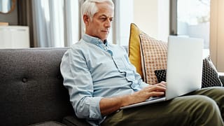 older man on laptop on couch gettyimages .jpg