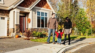 parents and child walking outside house lzHs.width .jpg