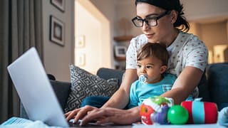 person using laptop with baby in front of them.jpg