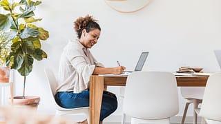 person at dining table writing in notebook TR.width .jpg